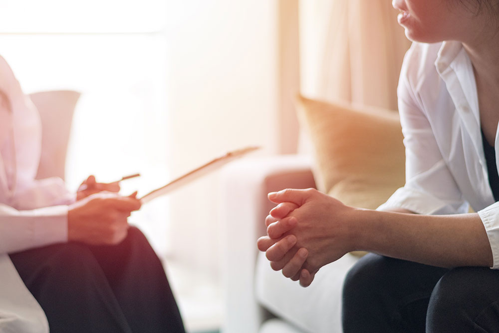 A woman sits on a couch, speaking to an Atlanta dating therapist during a dating counseling session.