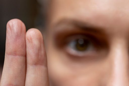 A close up of a person holding up two fingers and looking at the viewer. This image represents Brainspotting and how one follows a point during a Brainspotting session in Atlanta.