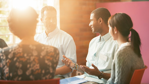 An image of a premarital counseling group. They are sitting in a circle discussing premartial counseling             