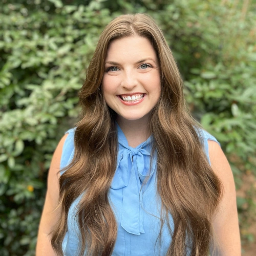 a woman wearing a blue blouse smiling