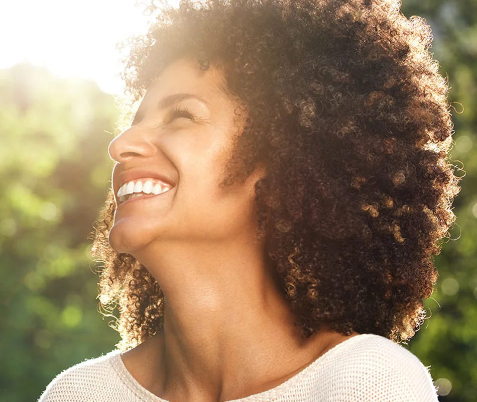 Smiling woman with voluminous curly brown hair