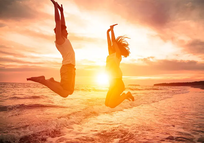 Teen-counseling-Fava-Counseling-GA Couple jumping at sunset beach